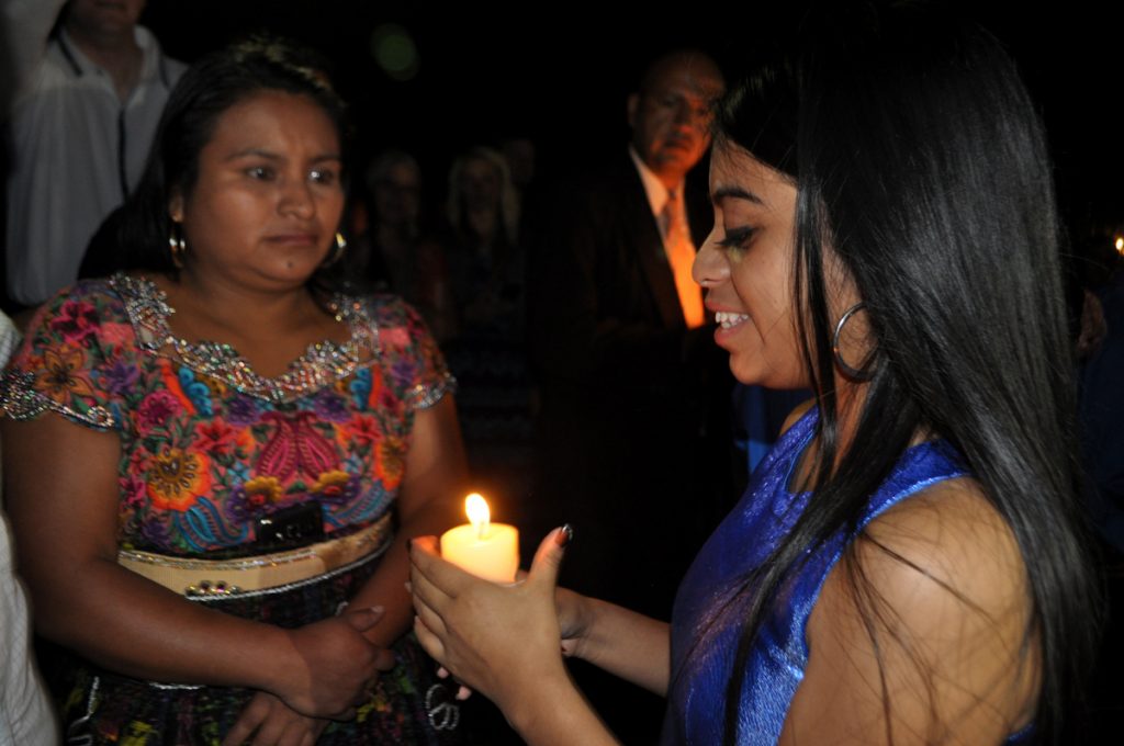 Maria Genoveva presents a candle to her mother during the ceremony in the garden of Hotel Real Plaza.
