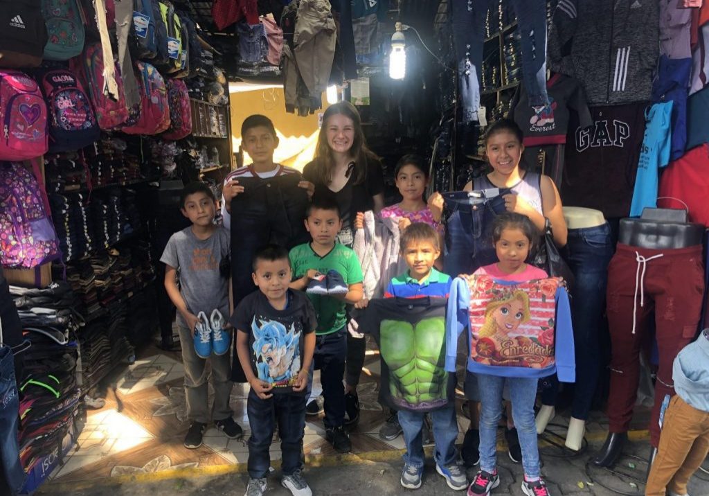 BreannaWatson1 GRACES' intern Breanna Watson stands in front of a store with a group of children from Escuela Integrada.